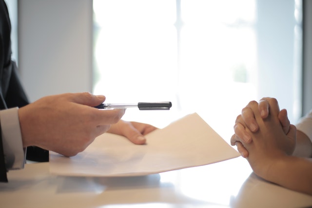 crop-businessman-giving-contract-to-woman-to-sign