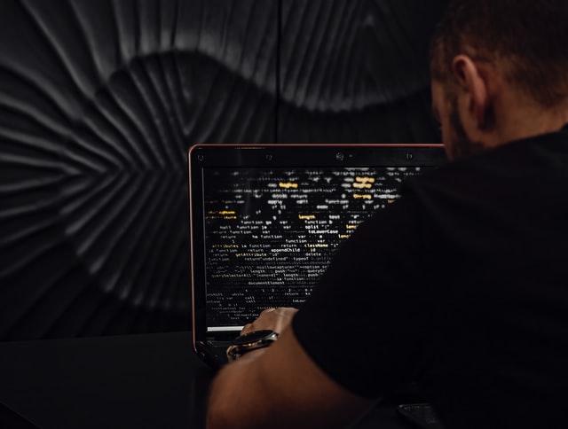 man-wearing-black-shirt-typing-laptop