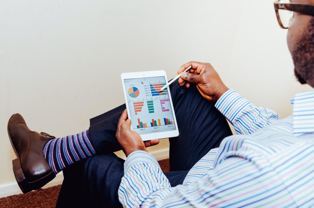 person-siting-on-chair-holding-tablet