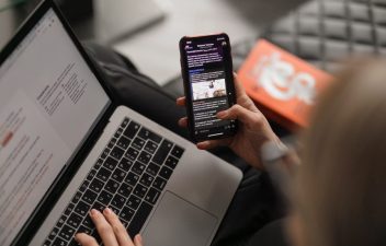 person checking laptop and browsing phone